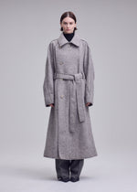 A model wears the ISSEY MIYAKE WOOLEN GRANITE woolen-granite-coat-beige-1.