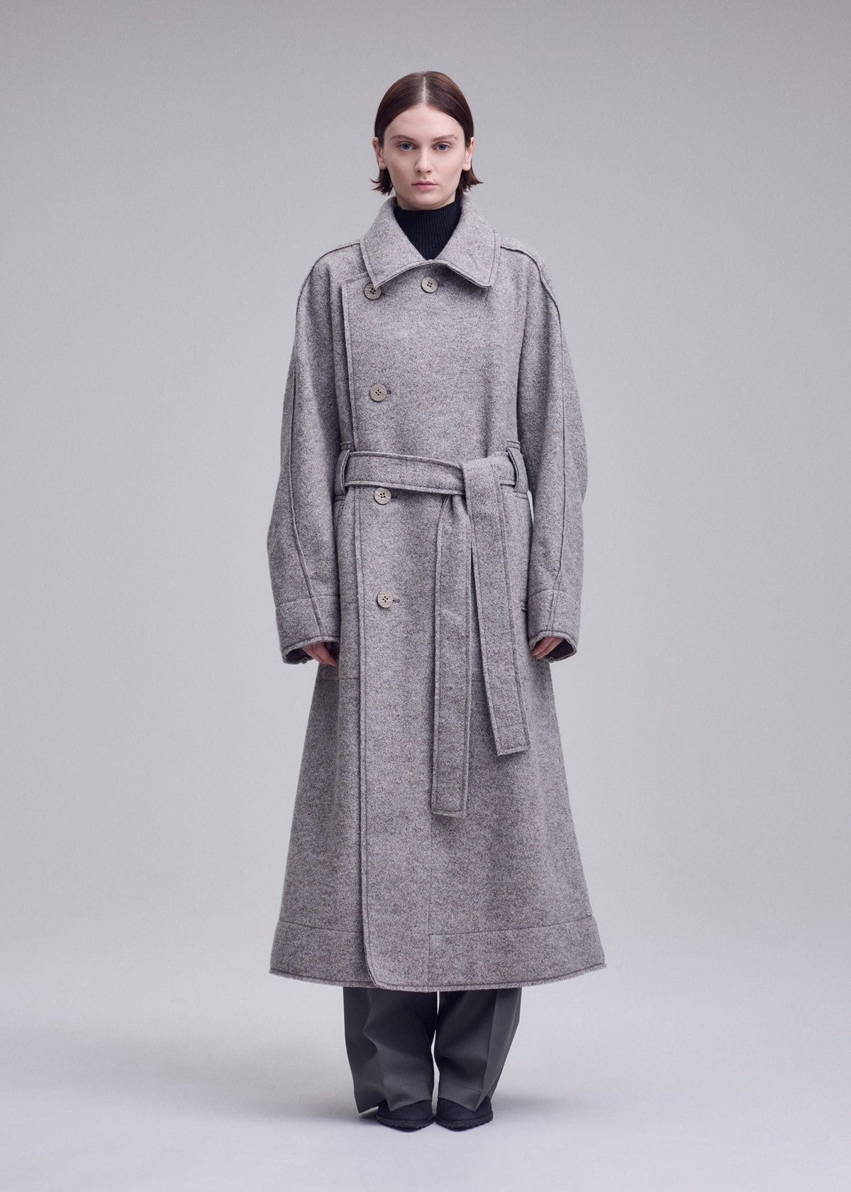 A model wears the ISSEY MIYAKE WOOLEN GRANITE woolen-granite-coat-beige-1.
