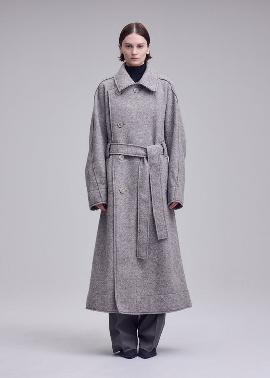 A model wears the ISSEY MIYAKE WOOLEN GRANITE woolen-granite-coat-beige-1.