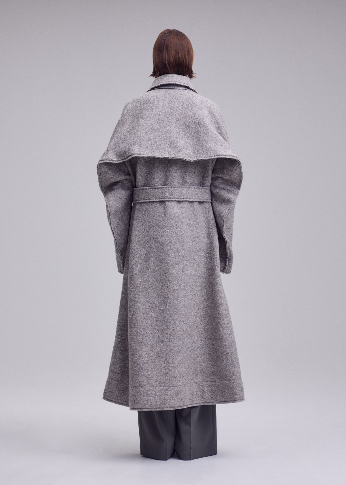 A model wears the ISSEY MIYAKE WOOLEN GRANITE woolen-granite-coat-beige-1.