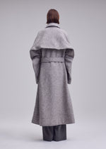 A model wears the ISSEY MIYAKE WOOLEN GRANITE woolen-granite-coat-beige-1.