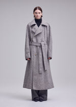 A model wears the ISSEY MIYAKE WOOLEN GRANITE woolen-granite-coat-beige-1.