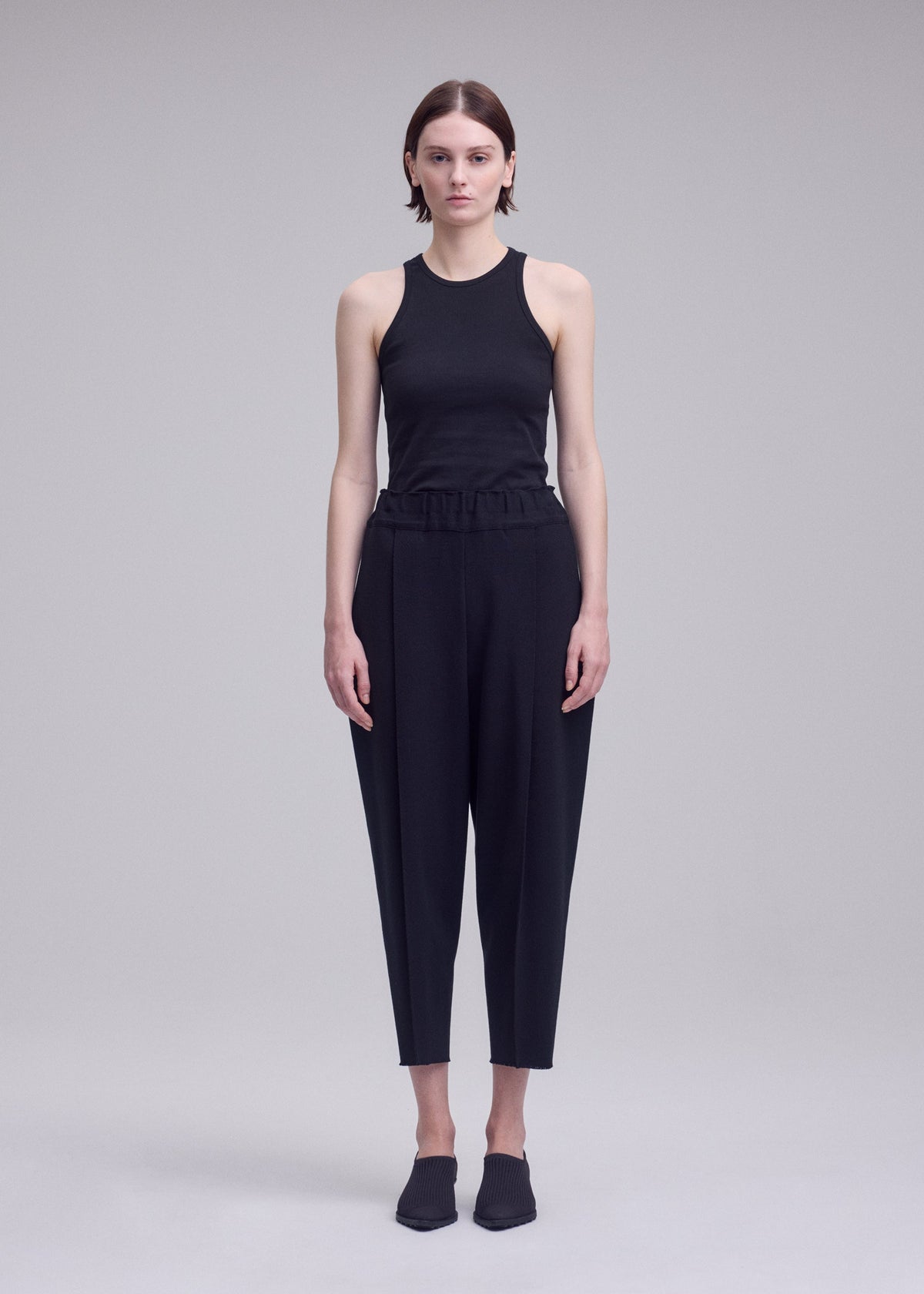 A model wears the ISSEY MIYAKE CAMPAGNE campagne-trousers-dark-navy.