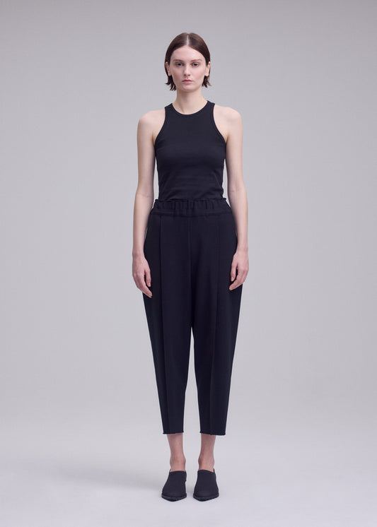 A model wears the ISSEY MIYAKE CAMPAGNE campagne-trousers-dark-navy.
