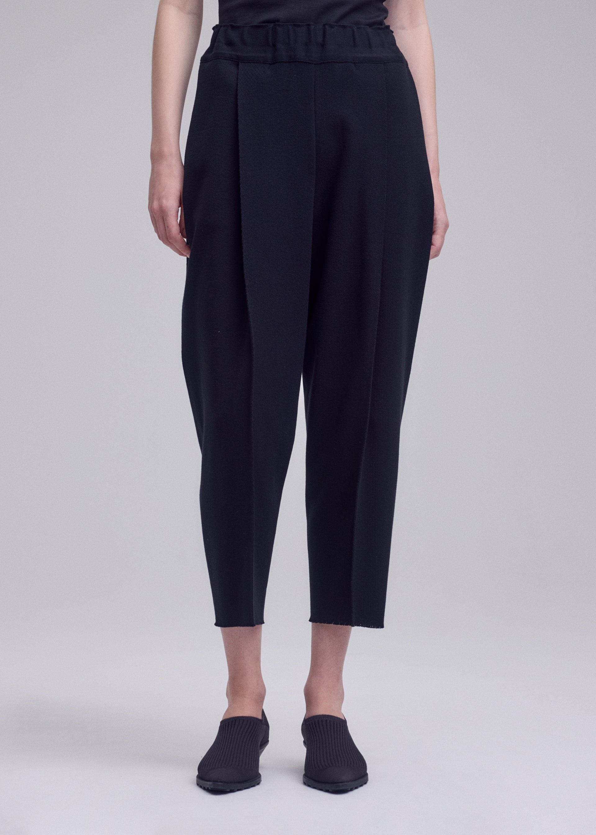 A model wears the ISSEY MIYAKE CAMPAGNE campagne-trousers-dark-navy.