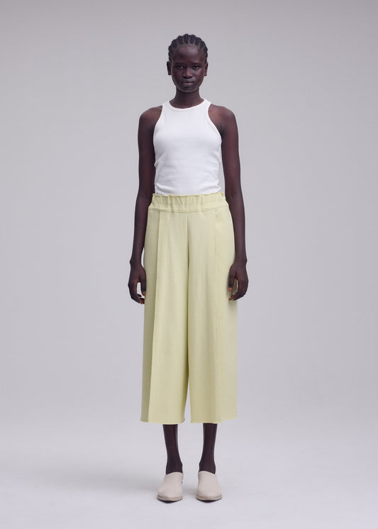 A model wears the ISSEY MIYAKE CAMPAGNE campagne-tapered-trousers-dark-navy.