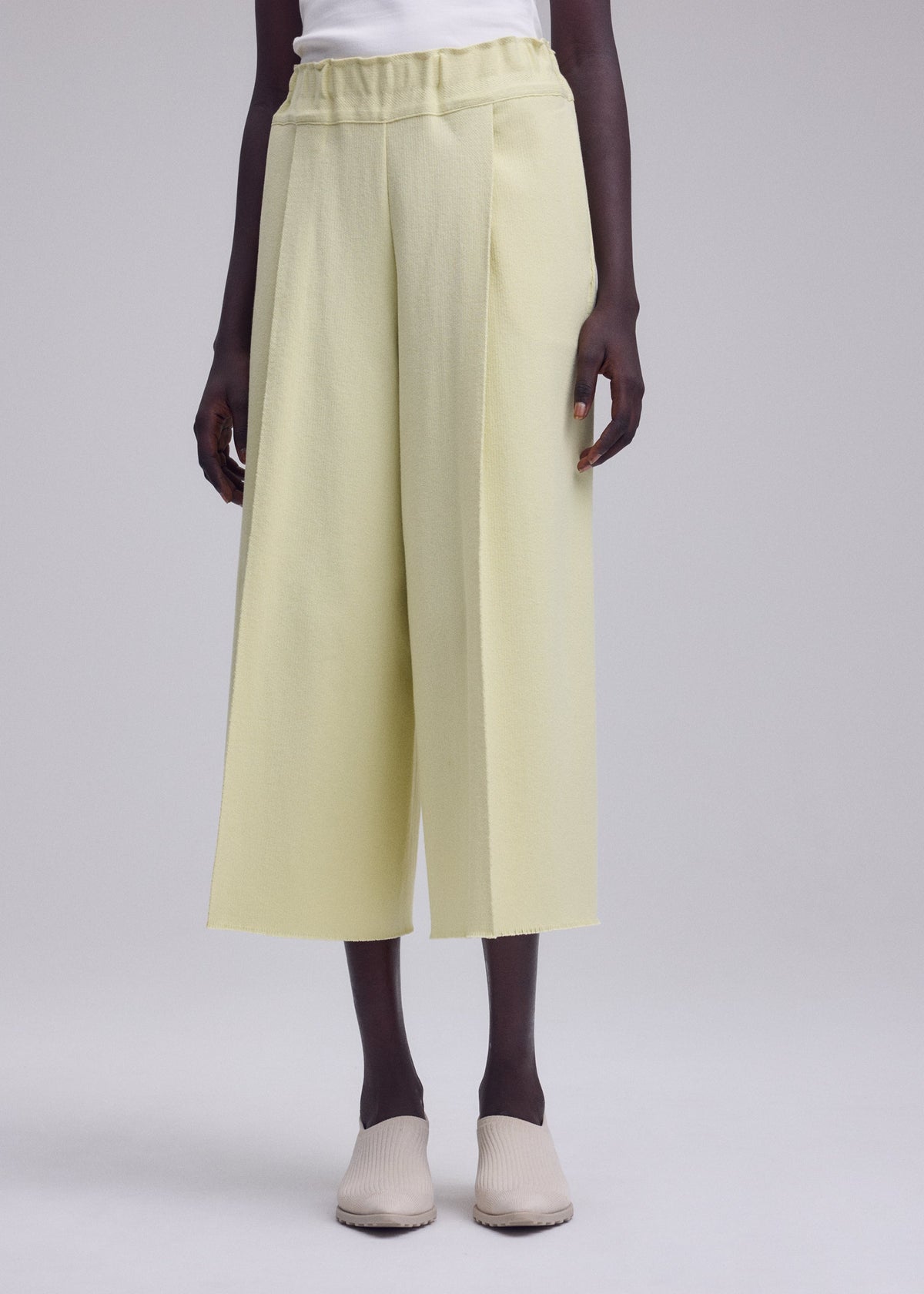 A model wears the ISSEY MIYAKE CAMPAGNE campagne-tapered-trousers-dark-navy.