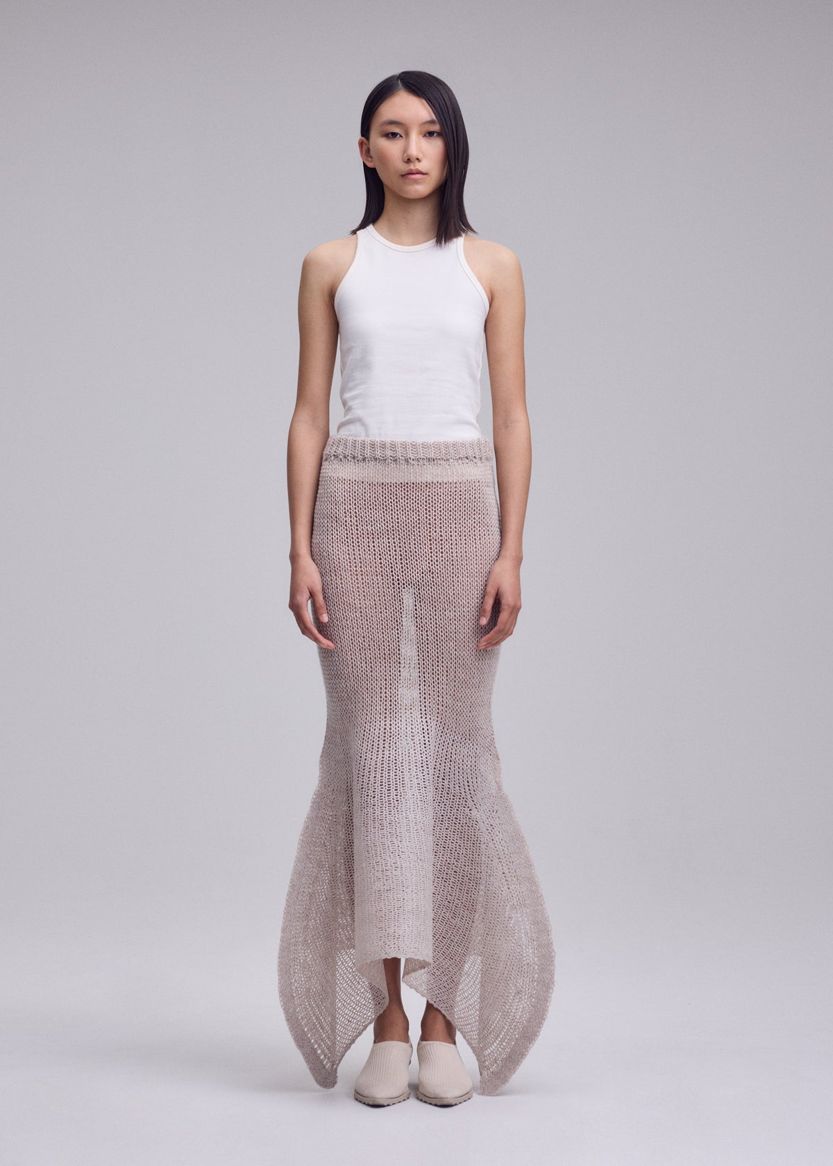 A model wears the ISSEY MIYAKE PANINI PULLED panini-pulled-skirt-light-beige.
