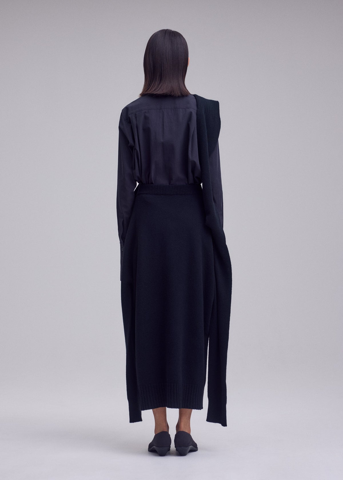 A model wears the ISSEY MIYAKE O KNIT o-knit-skirt-off-white.