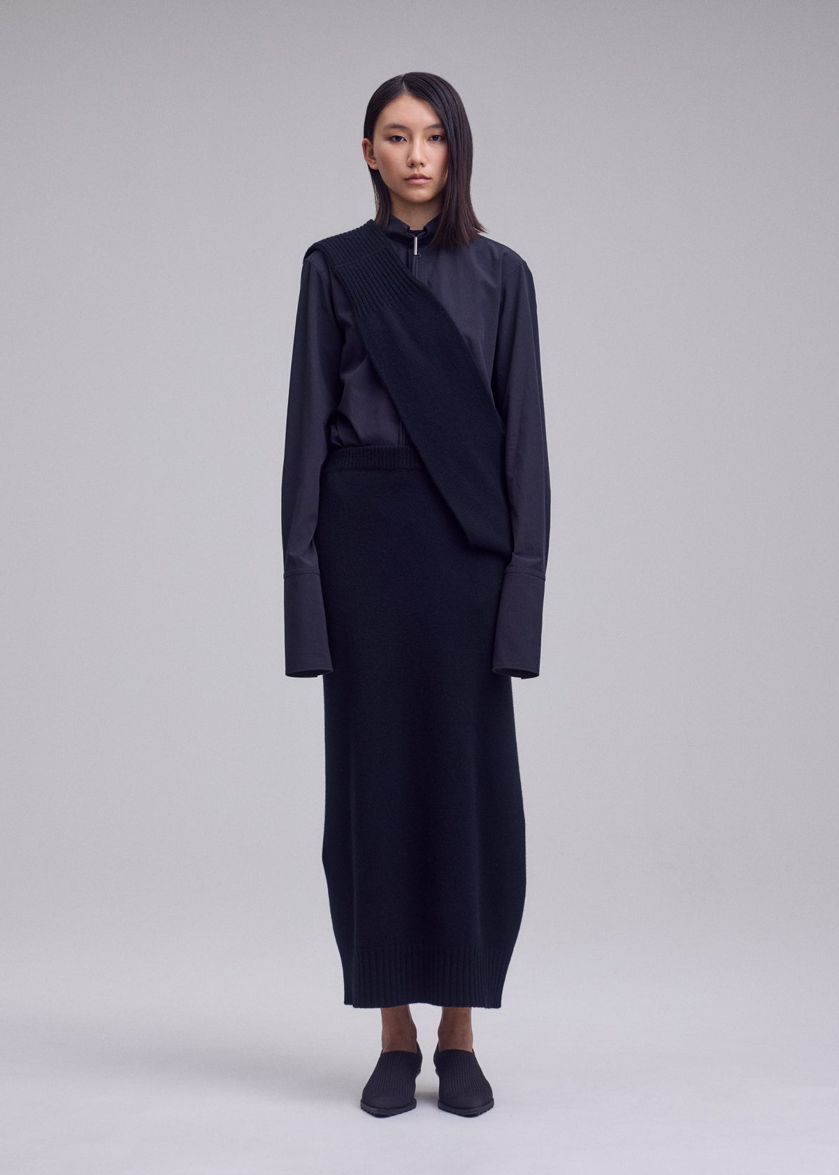 A model wears the ISSEY MIYAKE O KNIT o-knit-skirt-off-white.