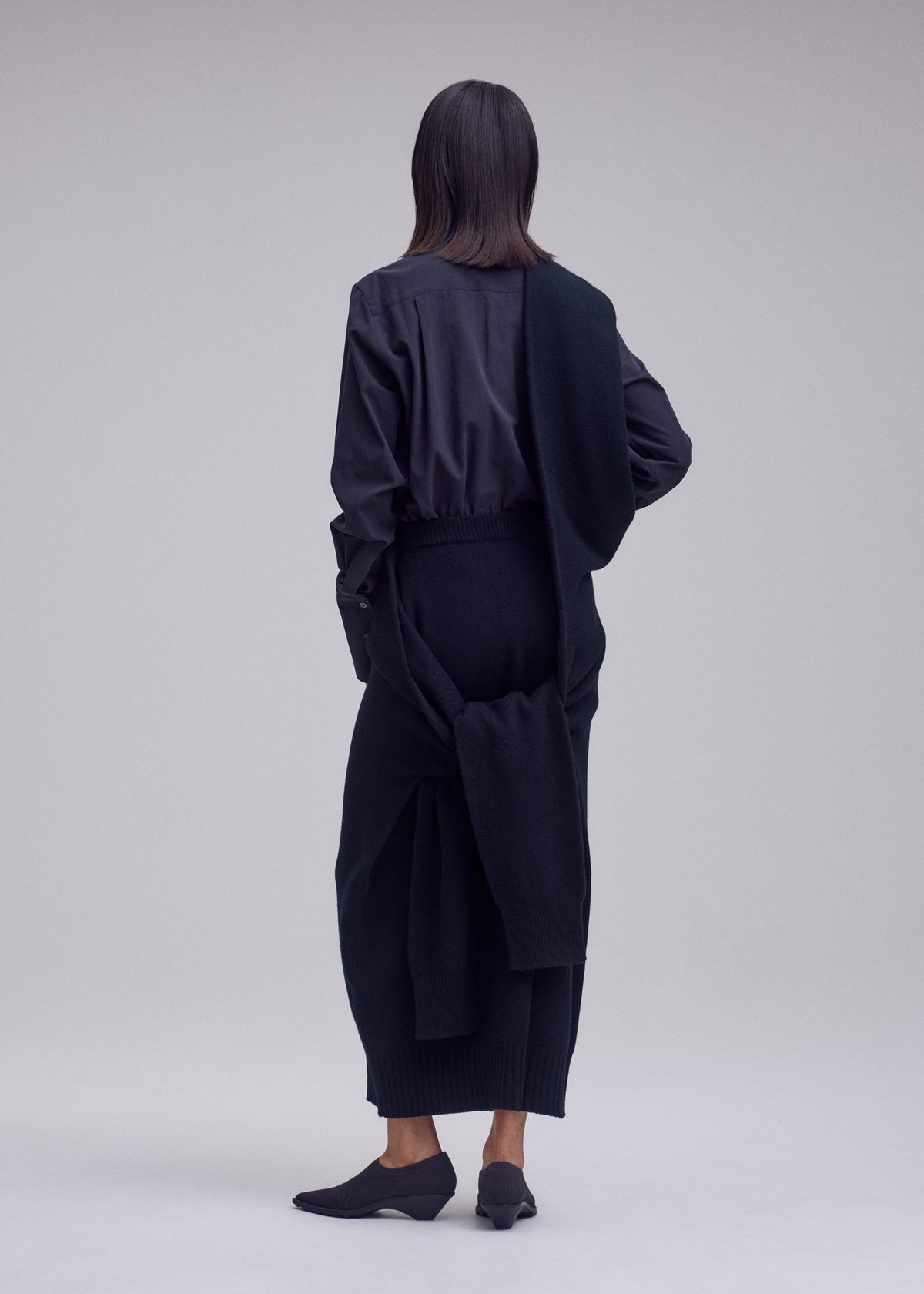 A model wears the ISSEY MIYAKE O KNIT o-knit-skirt-off-white.