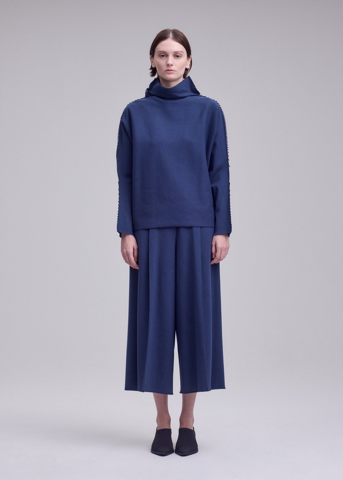 A model wears the ISSEY MIYAKE CAMPAGNE campagne-top-dark-navy.