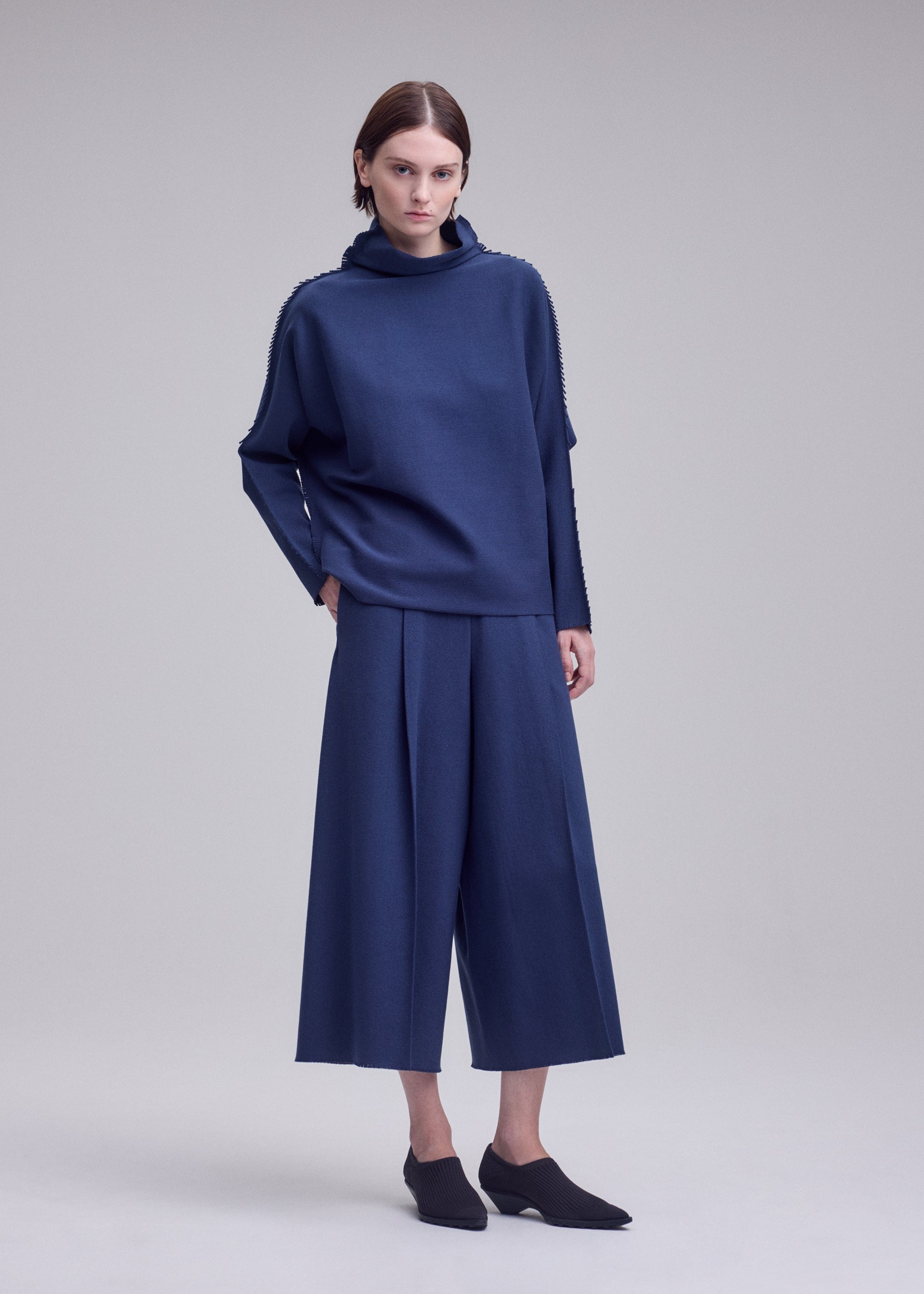 A model wears the ISSEY MIYAKE CAMPAGNE campagne-top-dark-navy.