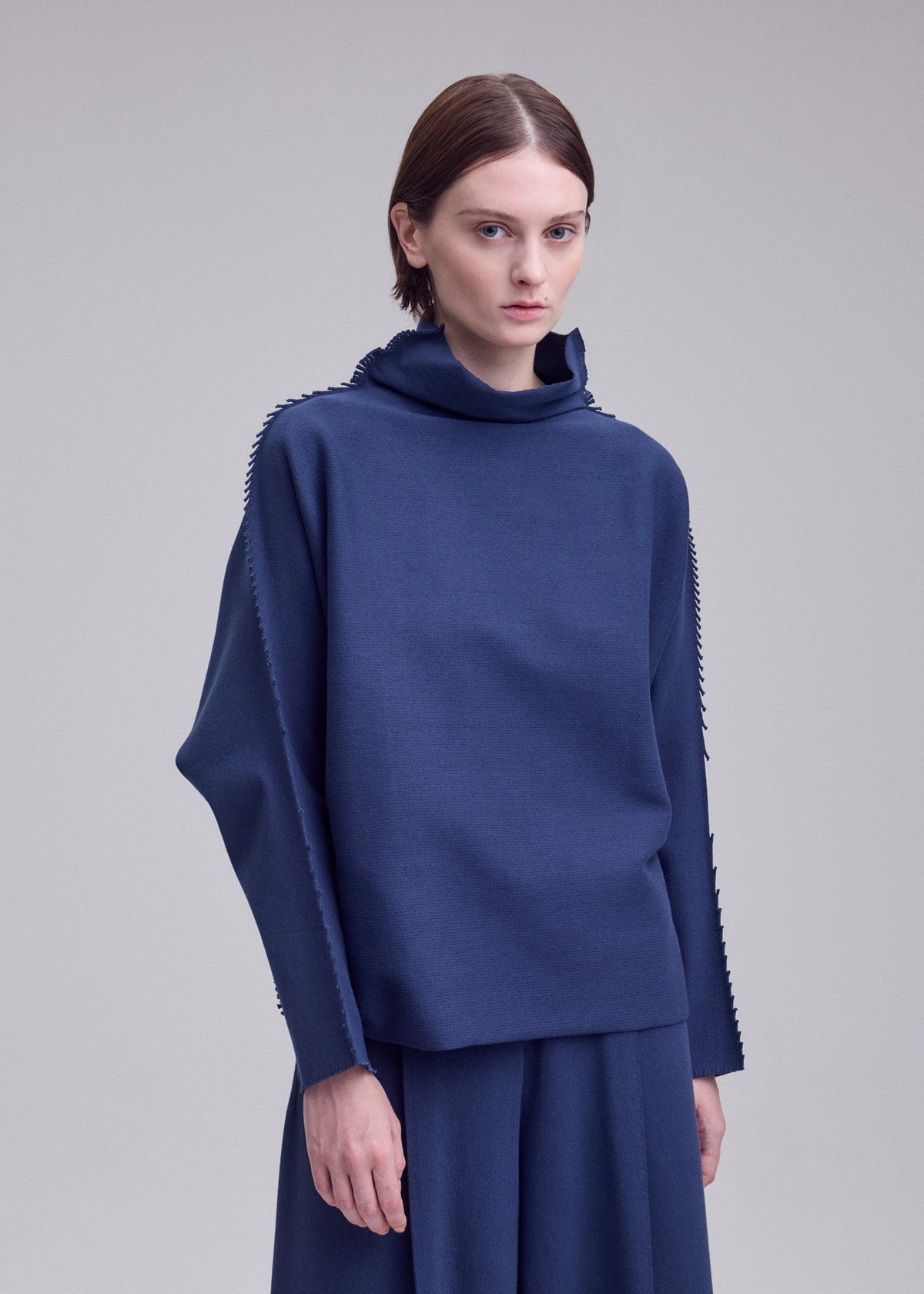 A model wears the ISSEY MIYAKE CAMPAGNE campagne-top-dark-navy.