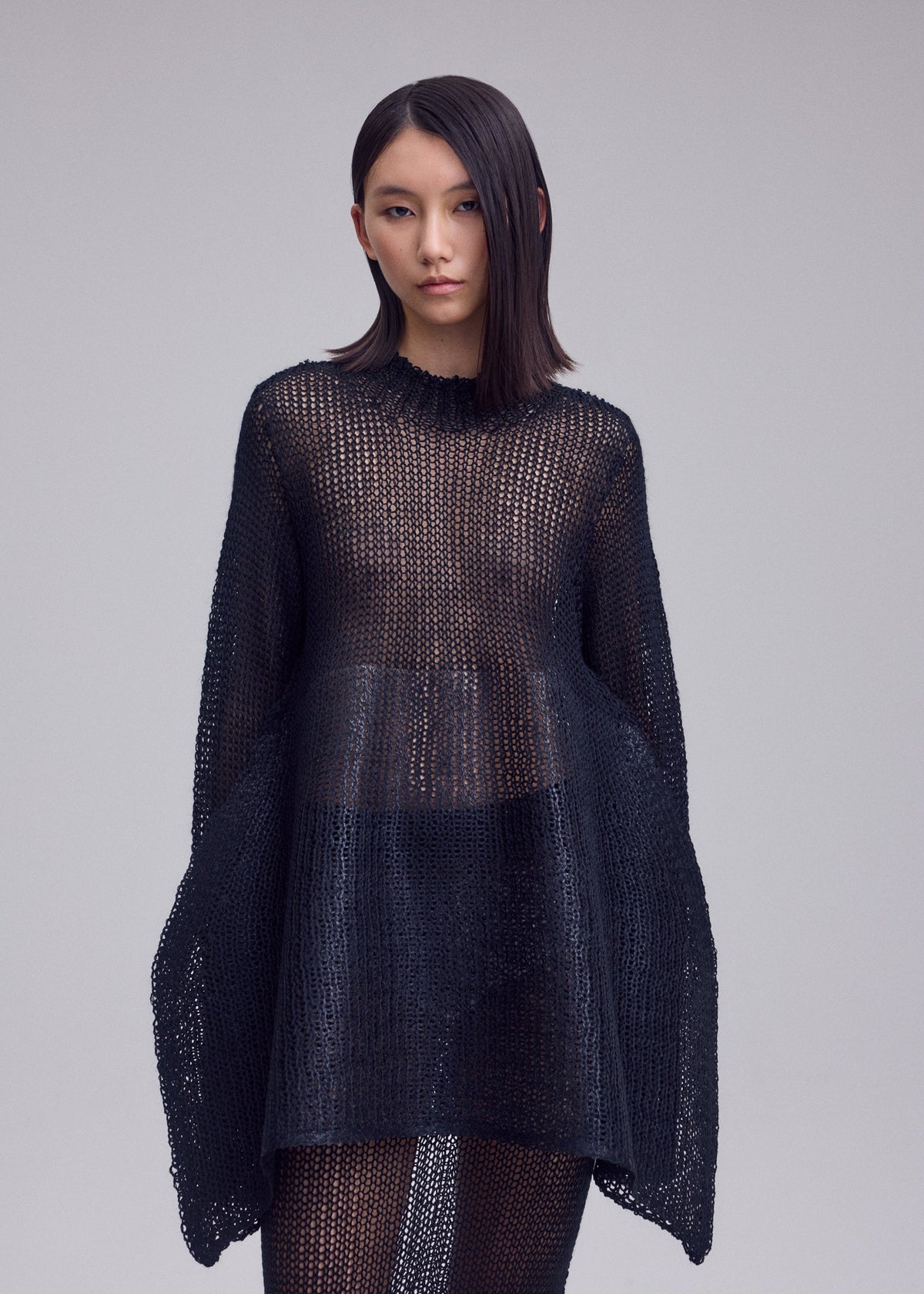 A model wears the ISSEY MIYAKE PANINI PULLED panini-pulled-top-light-beige.