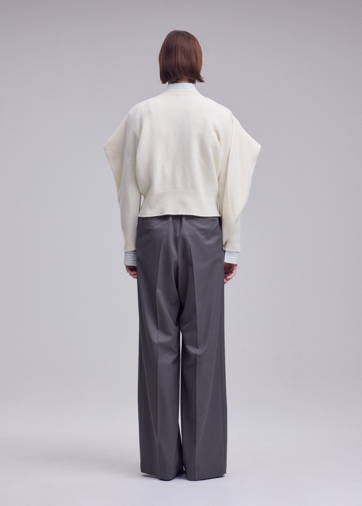 A model wears the ISSEY MIYAKE O KNIT o-knit-top-off-white.