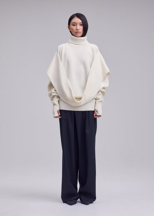 A model wears the ISSEY MIYAKE O KNIT o-knit-high-neck-top-black.