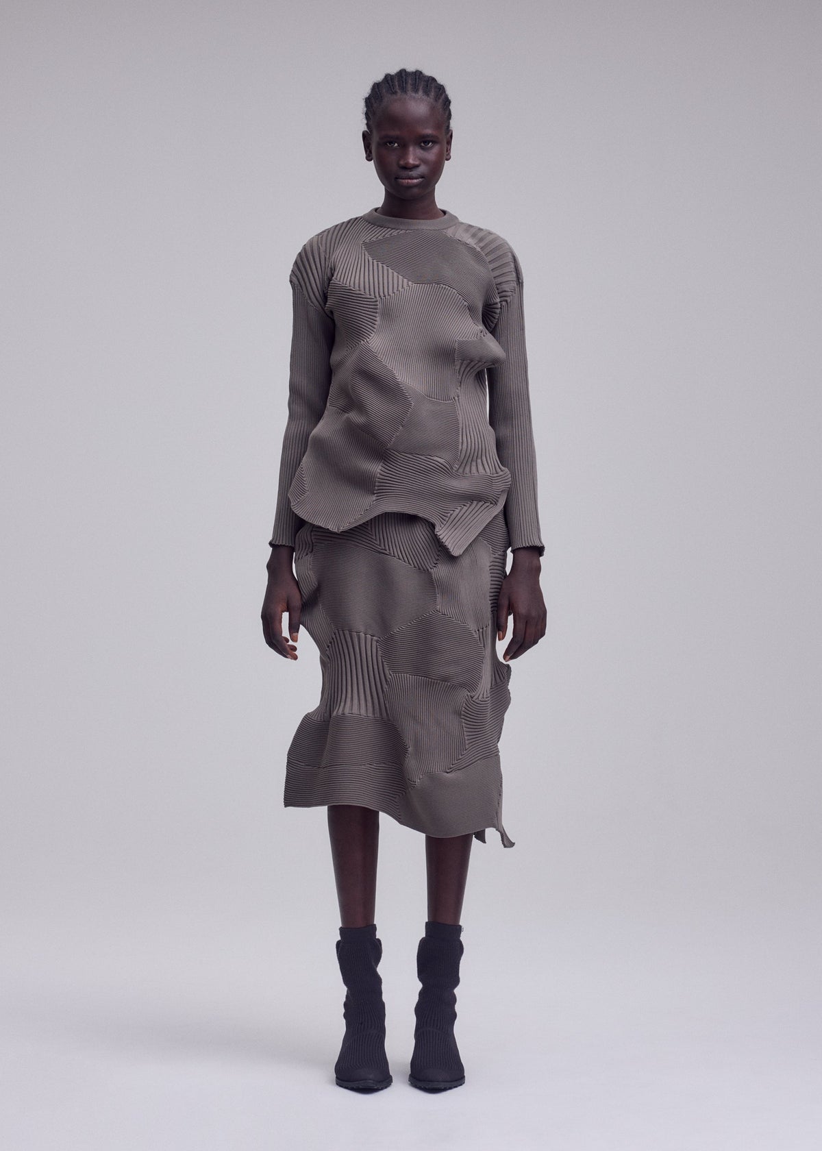 A model wears the ISSEY MIYAKE KONE KONE kone-kone-top-grey-1.