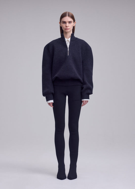 A model wears the ISSEY MIYAKE HANDSOME KNIT handsome-knit-high-neck-top-black.