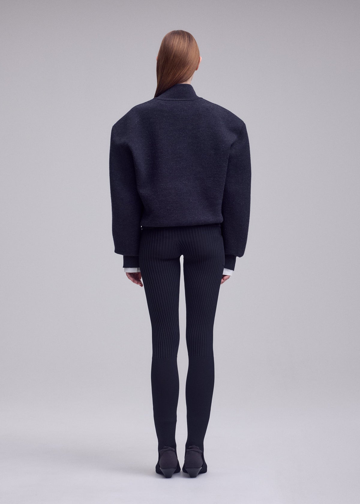 A model wears the ISSEY MIYAKE HANDSOME KNIT handsome-knit-high-neck-top-grey.