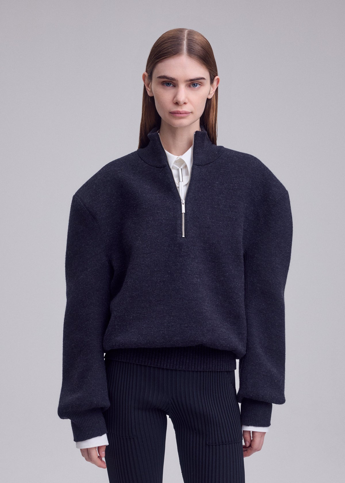 A model wears the ISSEY MIYAKE HANDSOME KNIT handsome-knit-high-neck-top-grey.