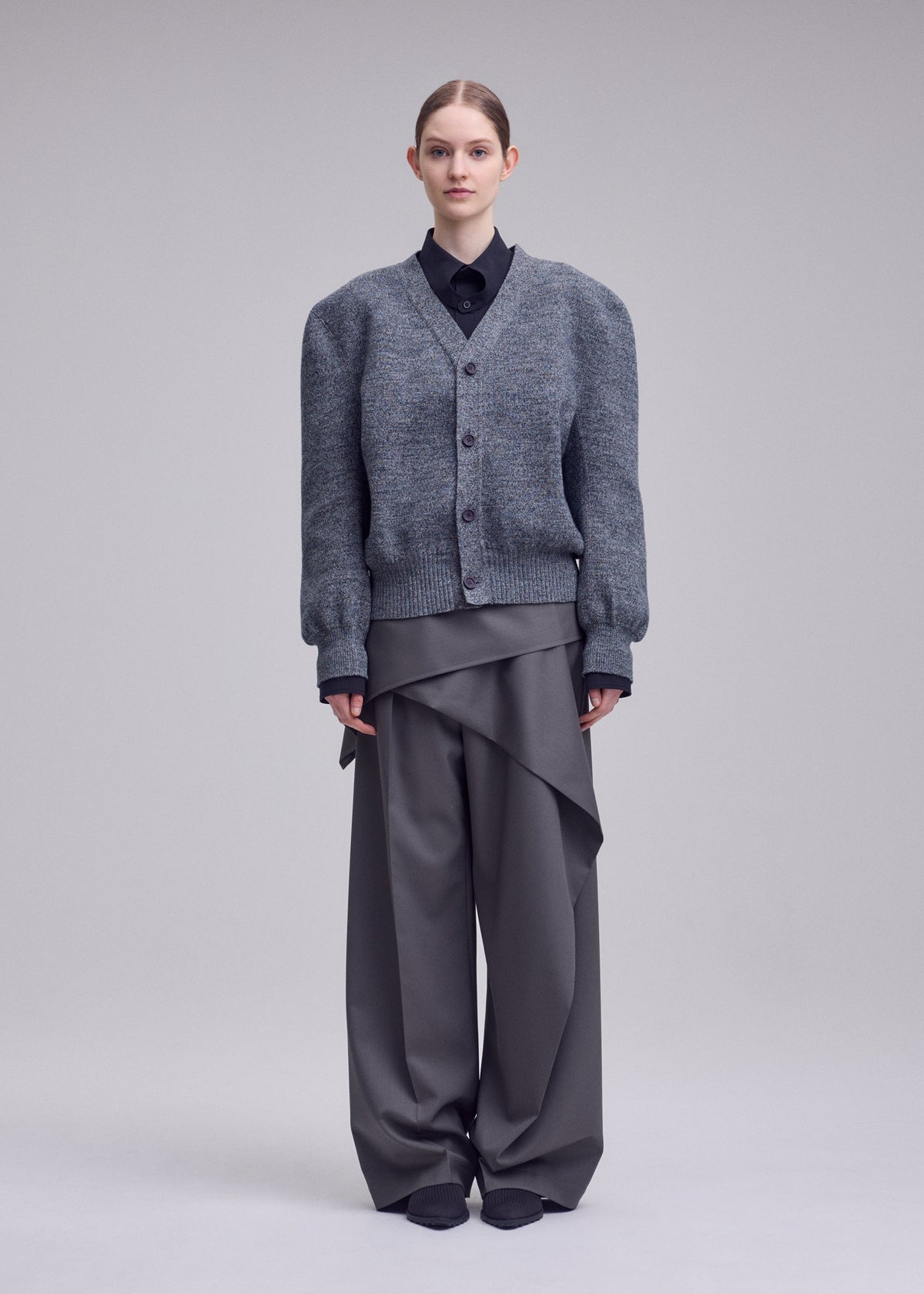 A model wears the ISSEY MIYAKE HANDSOME KNIT handsome-knit-cardigan-black.