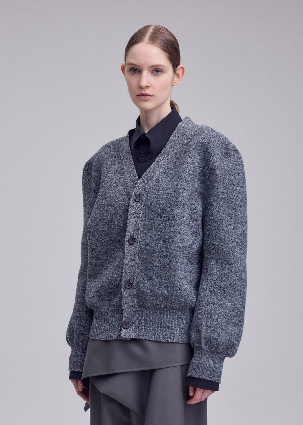 A model wears the ISSEY MIYAKE HANDSOME KNIT handsome-knit-cardigan-black.