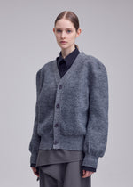 A model wears the ISSEY MIYAKE HANDSOME KNIT handsome-knit-cardigan-black.