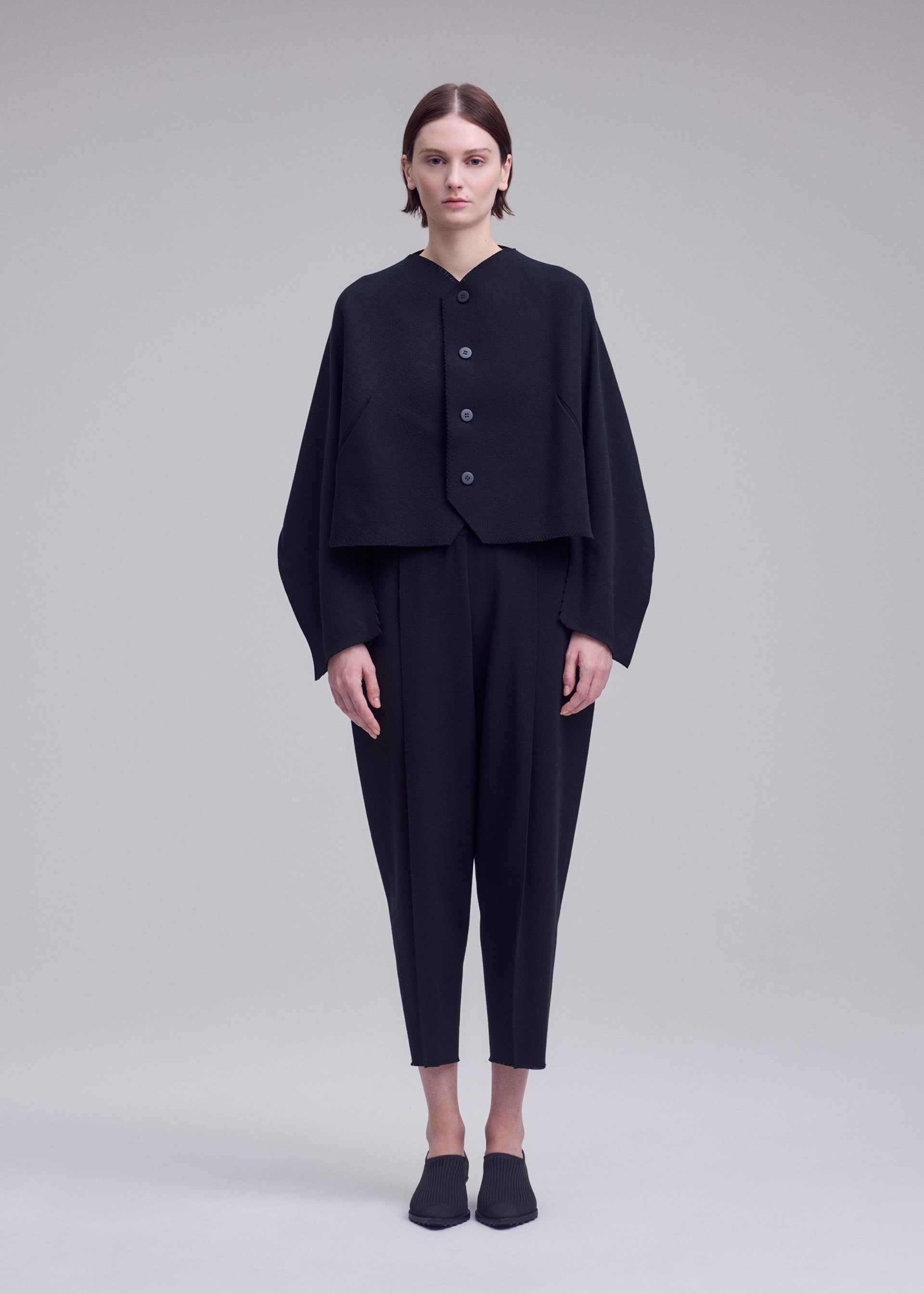 A model wears the ISSEY MIYAKE CAMPAGNE campagne-button-front-cardigan-dark-navy.