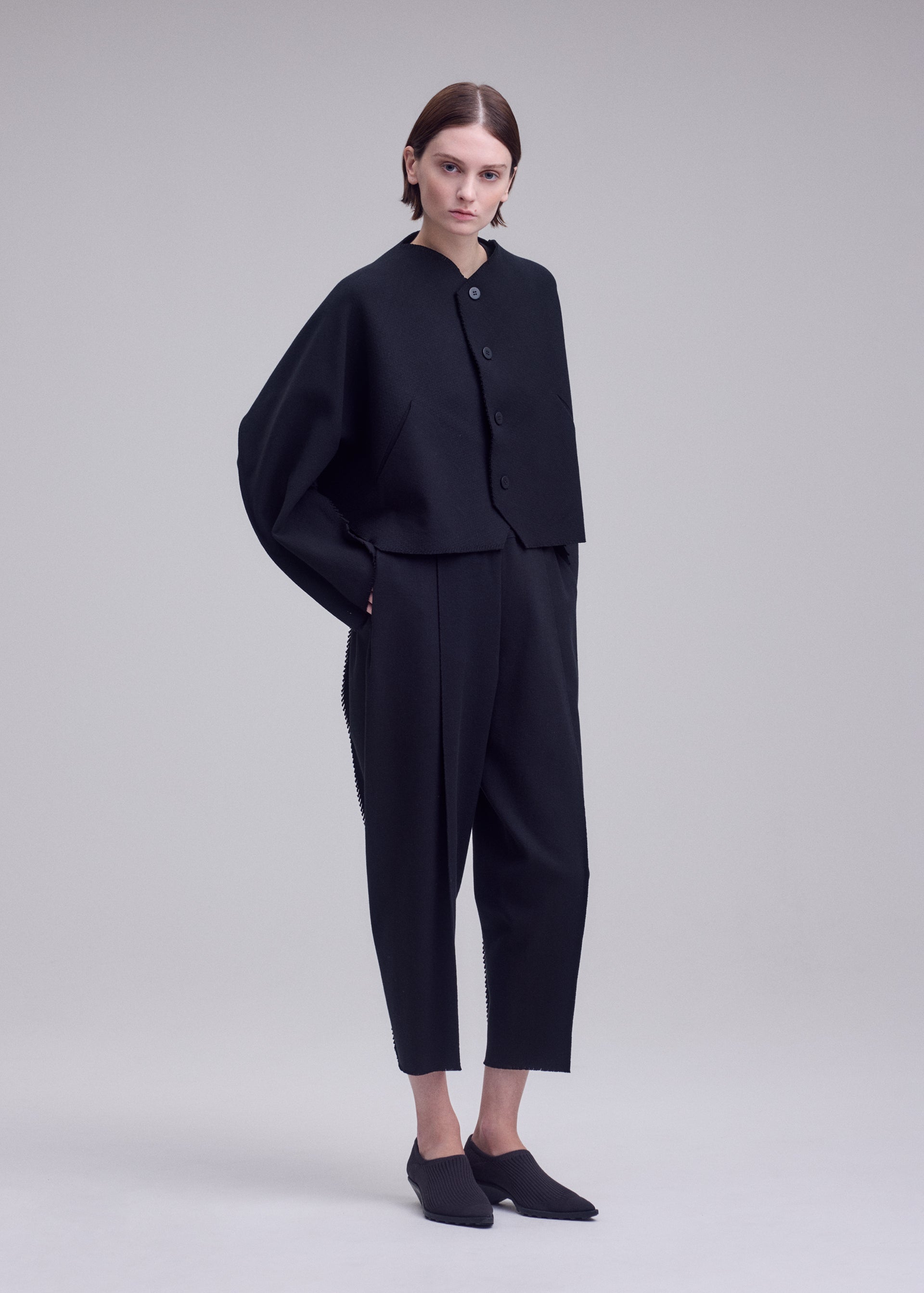A model wears the ISSEY MIYAKE CAMPAGNE campagne-button-front-cardigan-dark-navy.