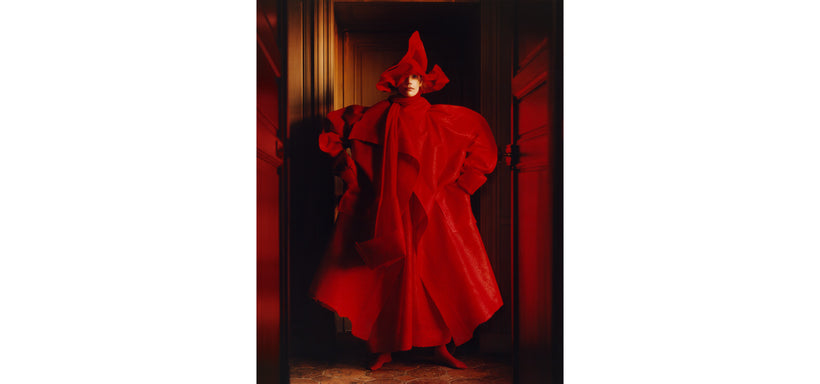 Centre: Model wearing PANINI coat and trousers in Red, striking a firm pose in a dimly lit room.