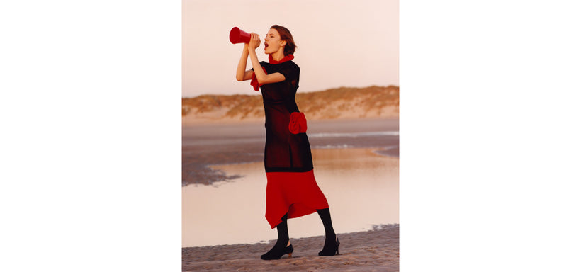 Centre: Model wearing LIFE FORM Dress in Macaw Red, in an expressive pose against a mountain background.