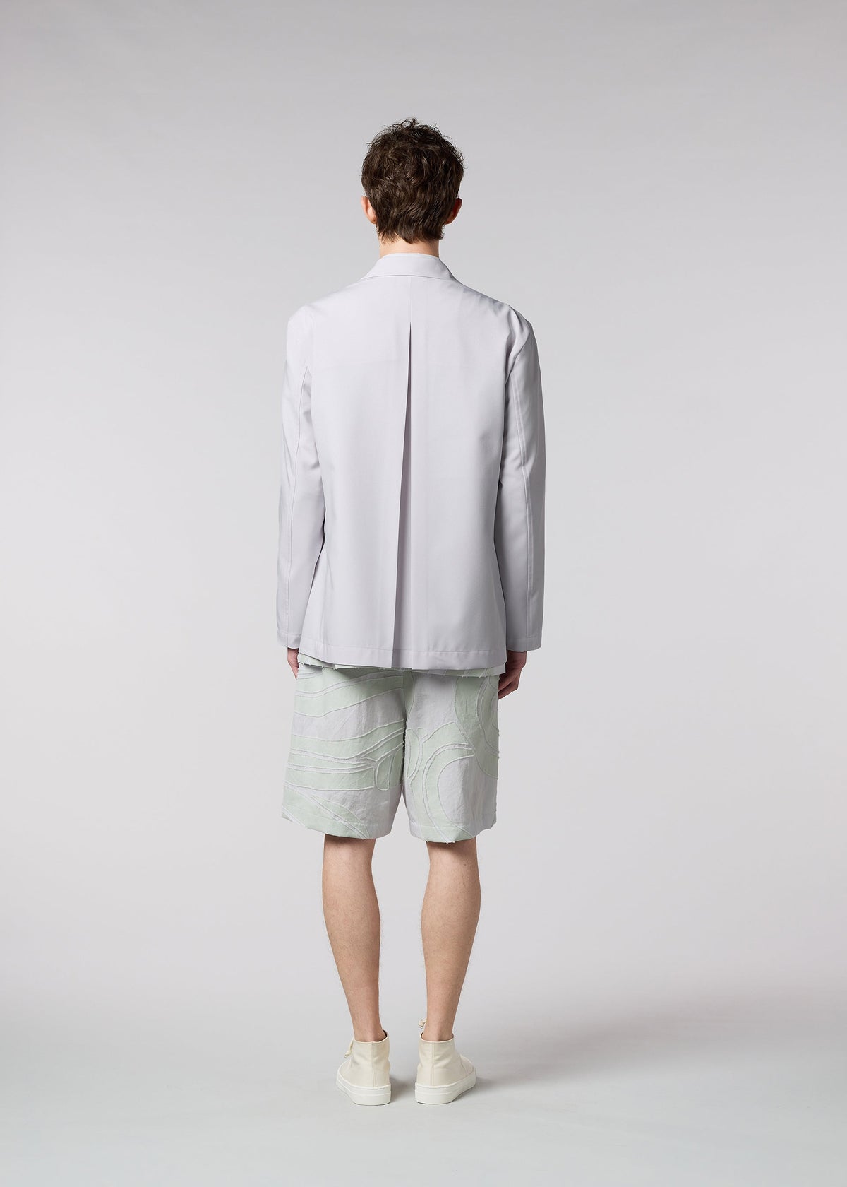 A model wears the ISSEY MIYAKE MEN WINGS jacket.