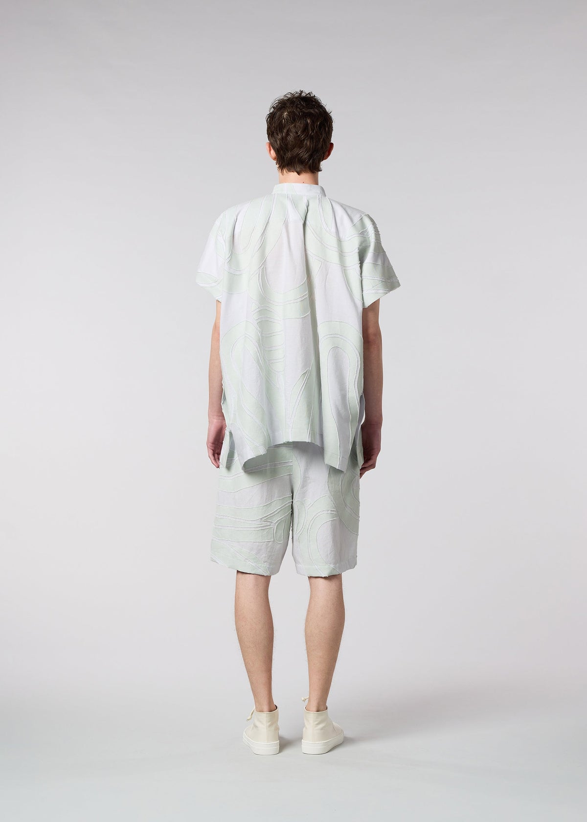A model wears the ISSEY MIYAKE MEN SCENES trousers.