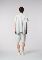 A model wears the ISSEY MIYAKE MEN SCENES shirt.