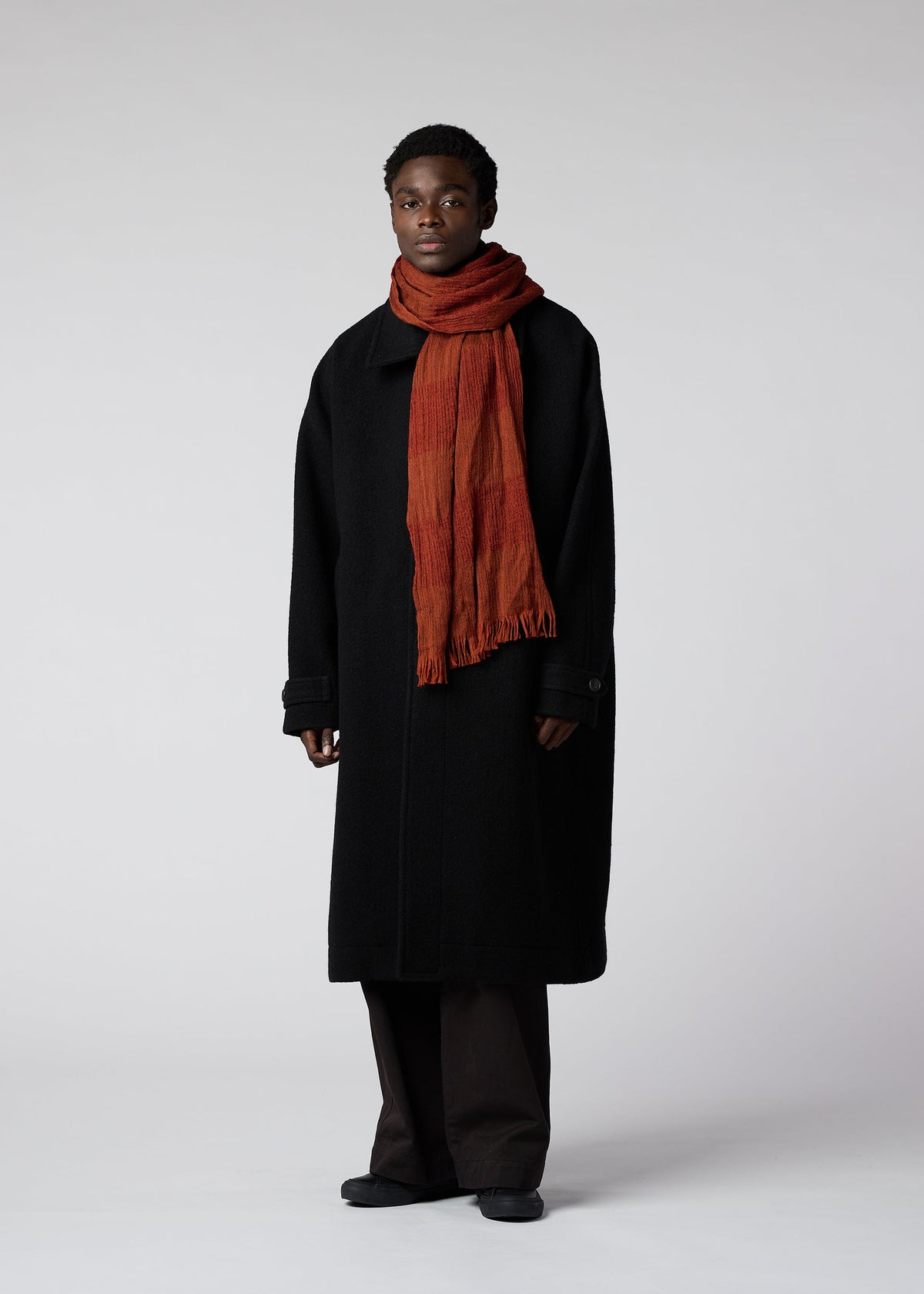 A model wears the IM MEN WOOL TUCK STOLE stole.