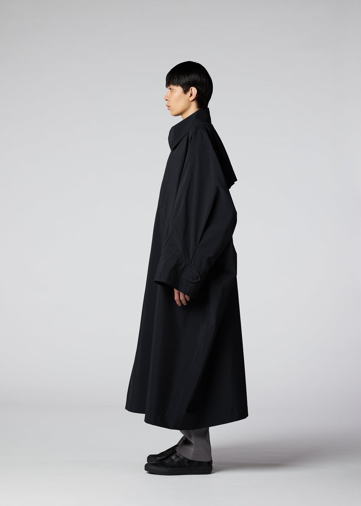 A model wears the IM MEN WIND COAT LIGHT clothing.