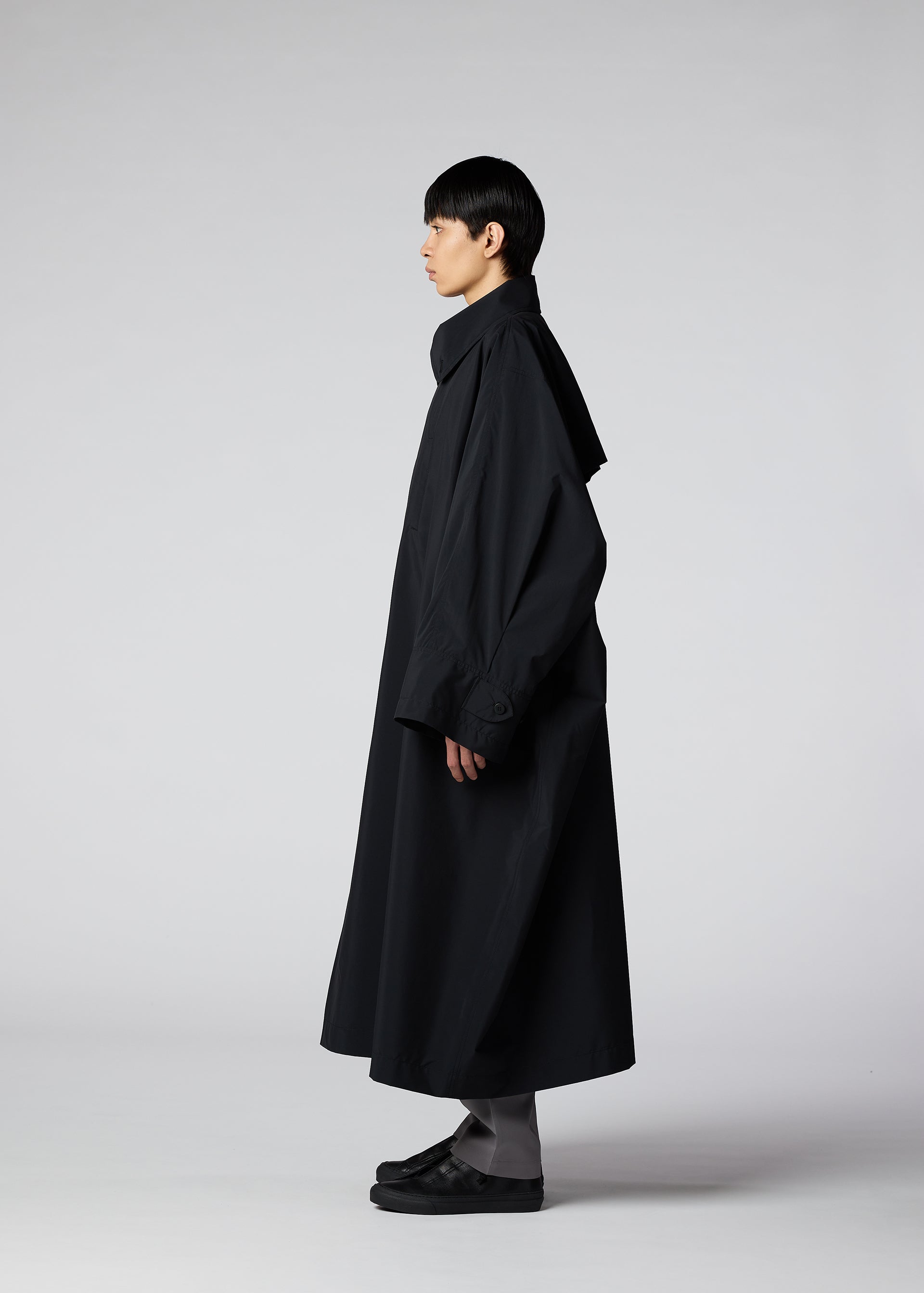A model wears the IM MEN WIND COAT LIGHT clothing.