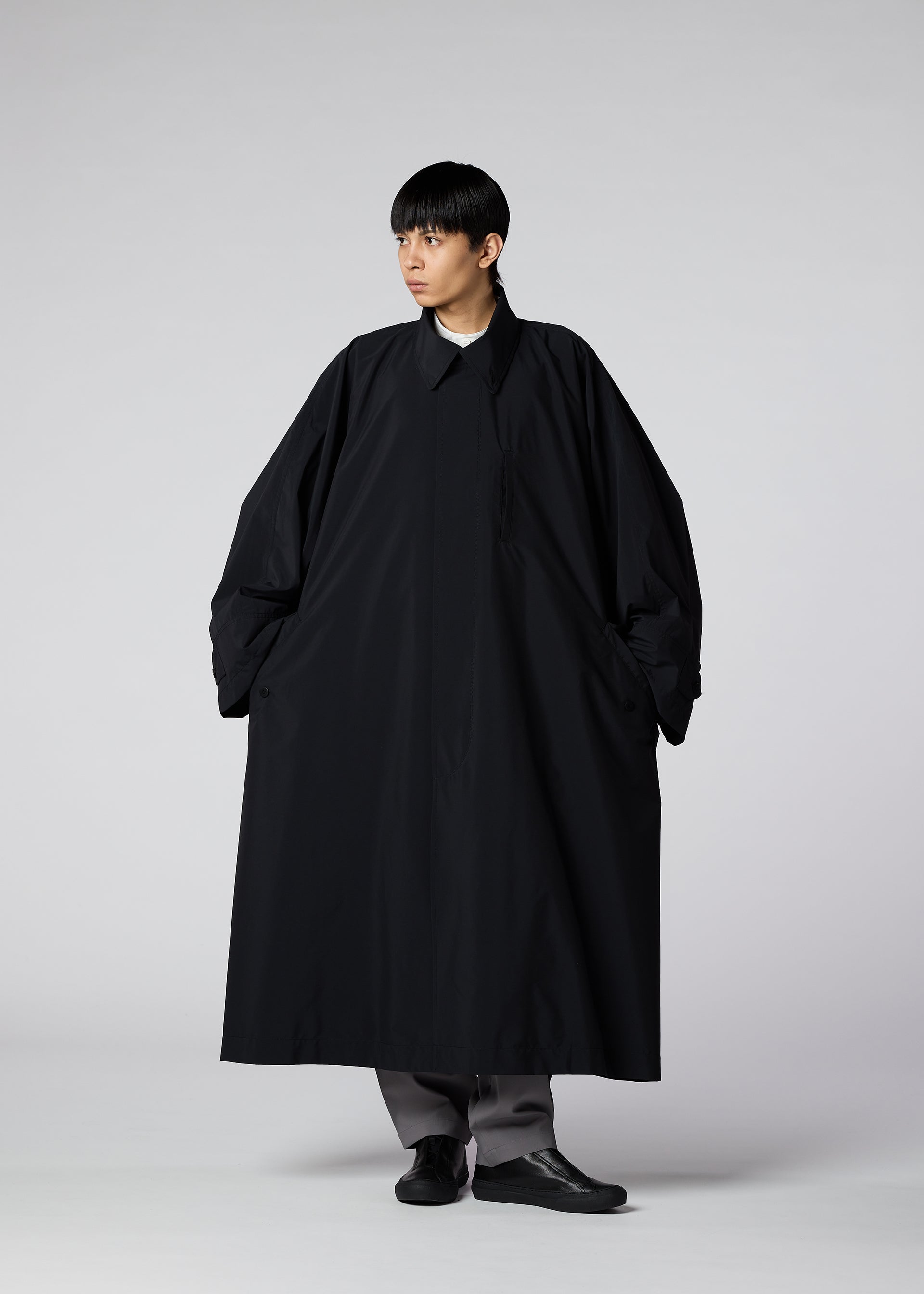 A model wears the IM MEN WIND COAT LIGHT clothing.