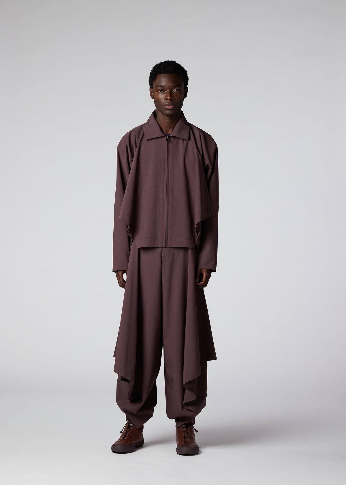 A model wears the IM MEN FLAT DRAPE clothing.