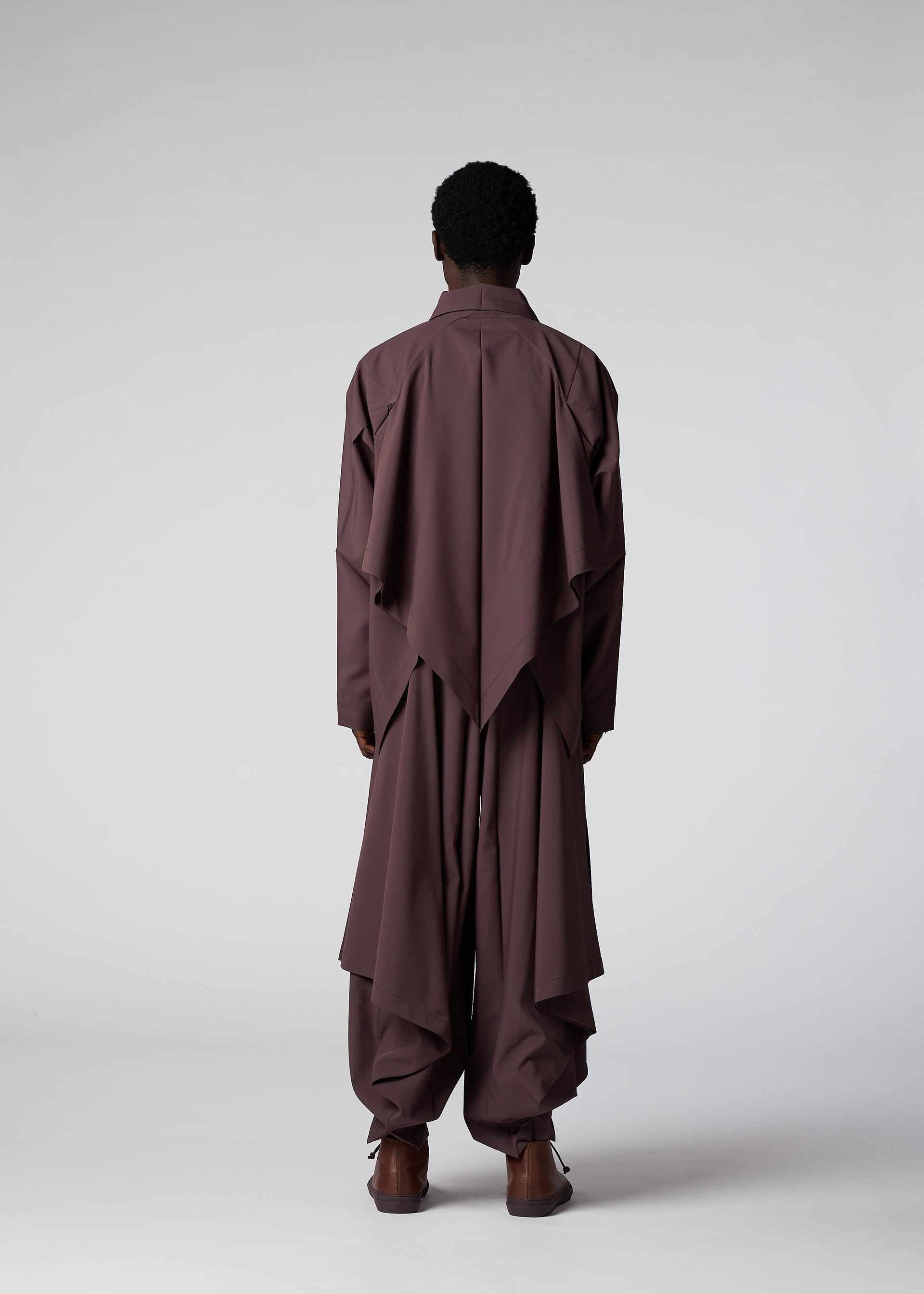 A model wears the IM MEN FLAT DRAPE clothing.