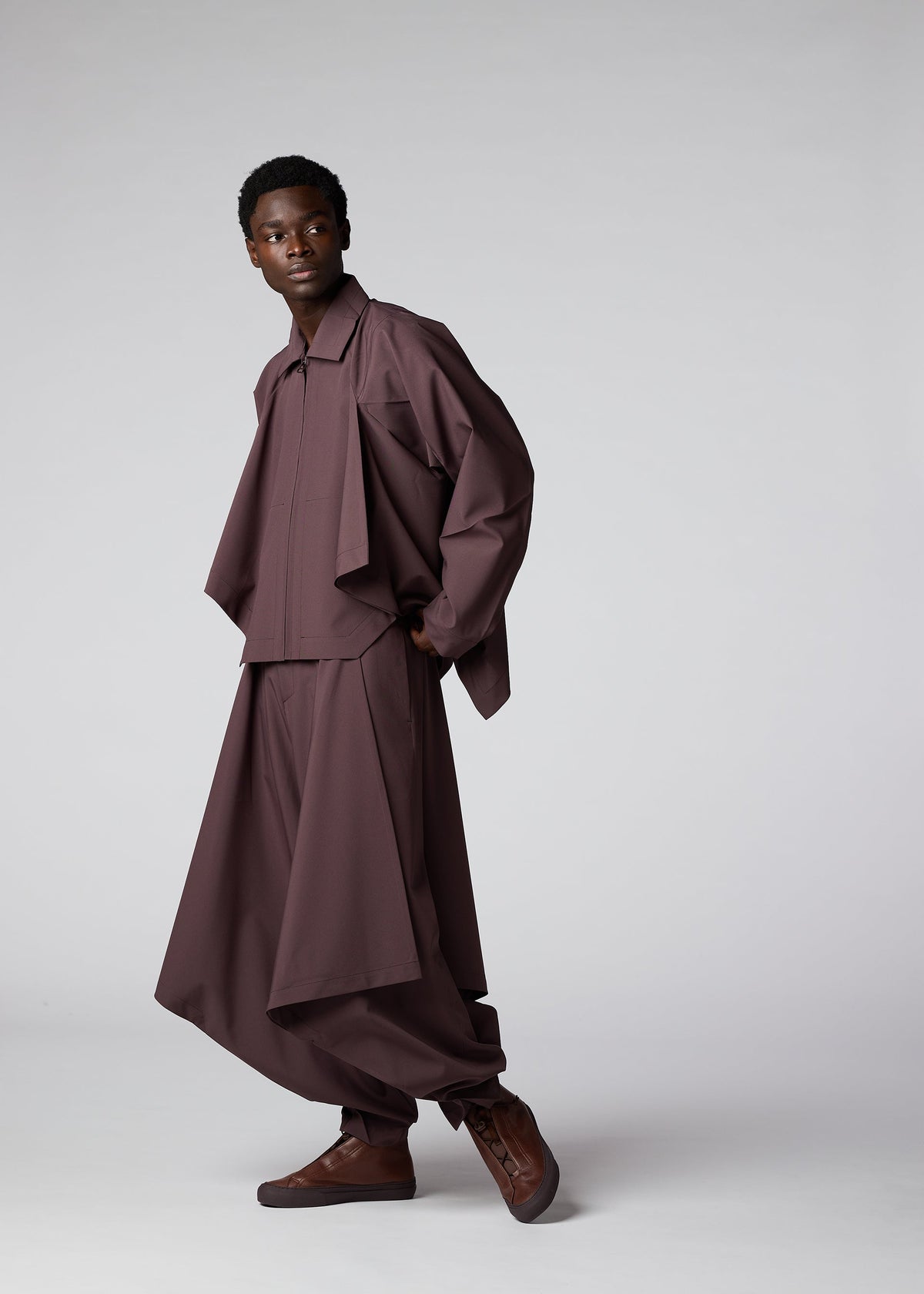 A model wears the IM MEN FLAT DRAPE clothing.
