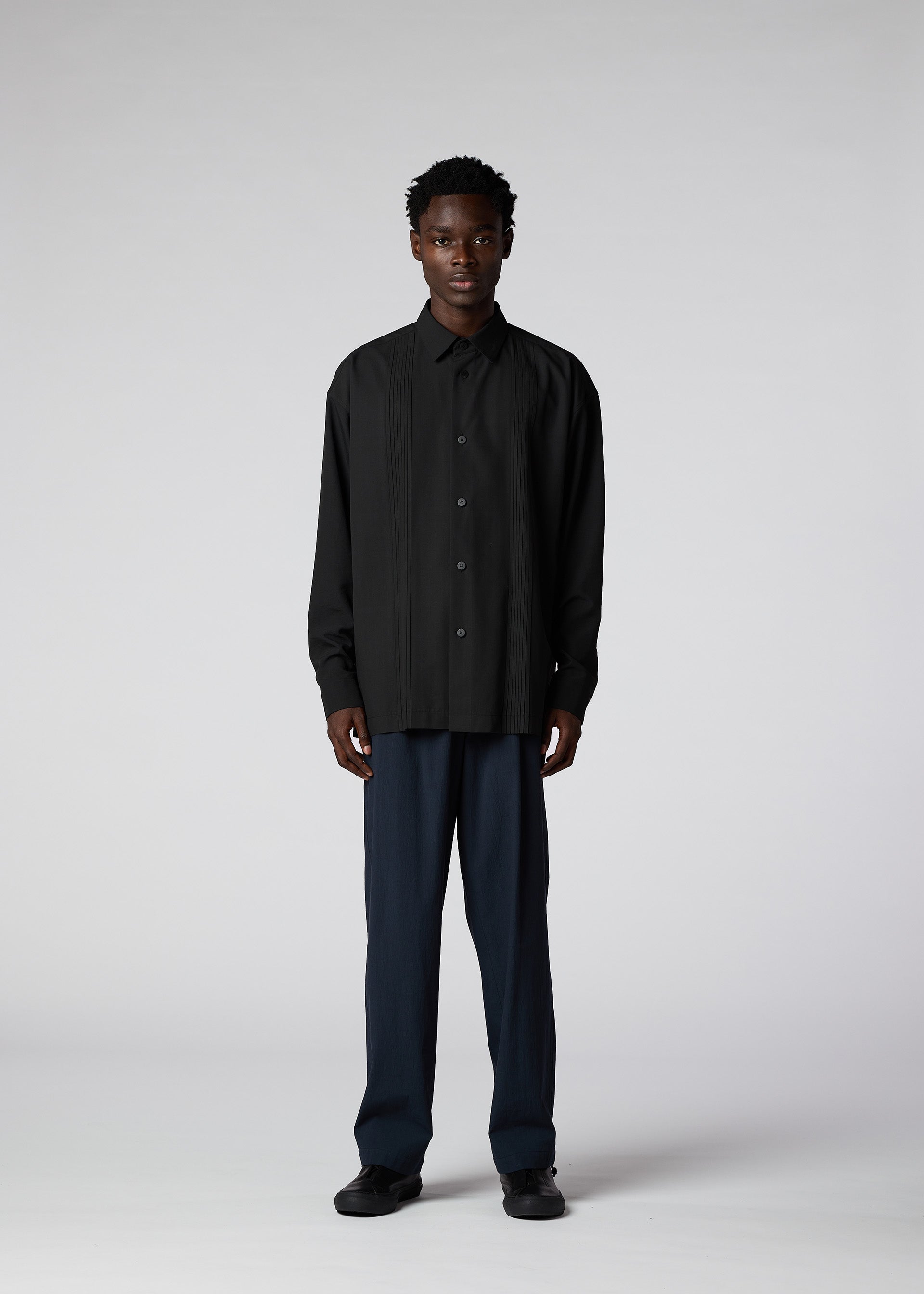 A model wears the IM MEN PLEATS SHIRT shirt.