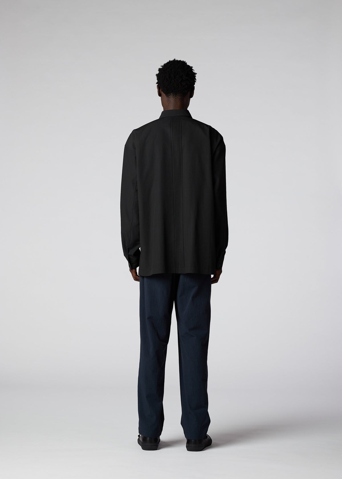 A model wears the IM MEN PLEATS SHIRT shirt.