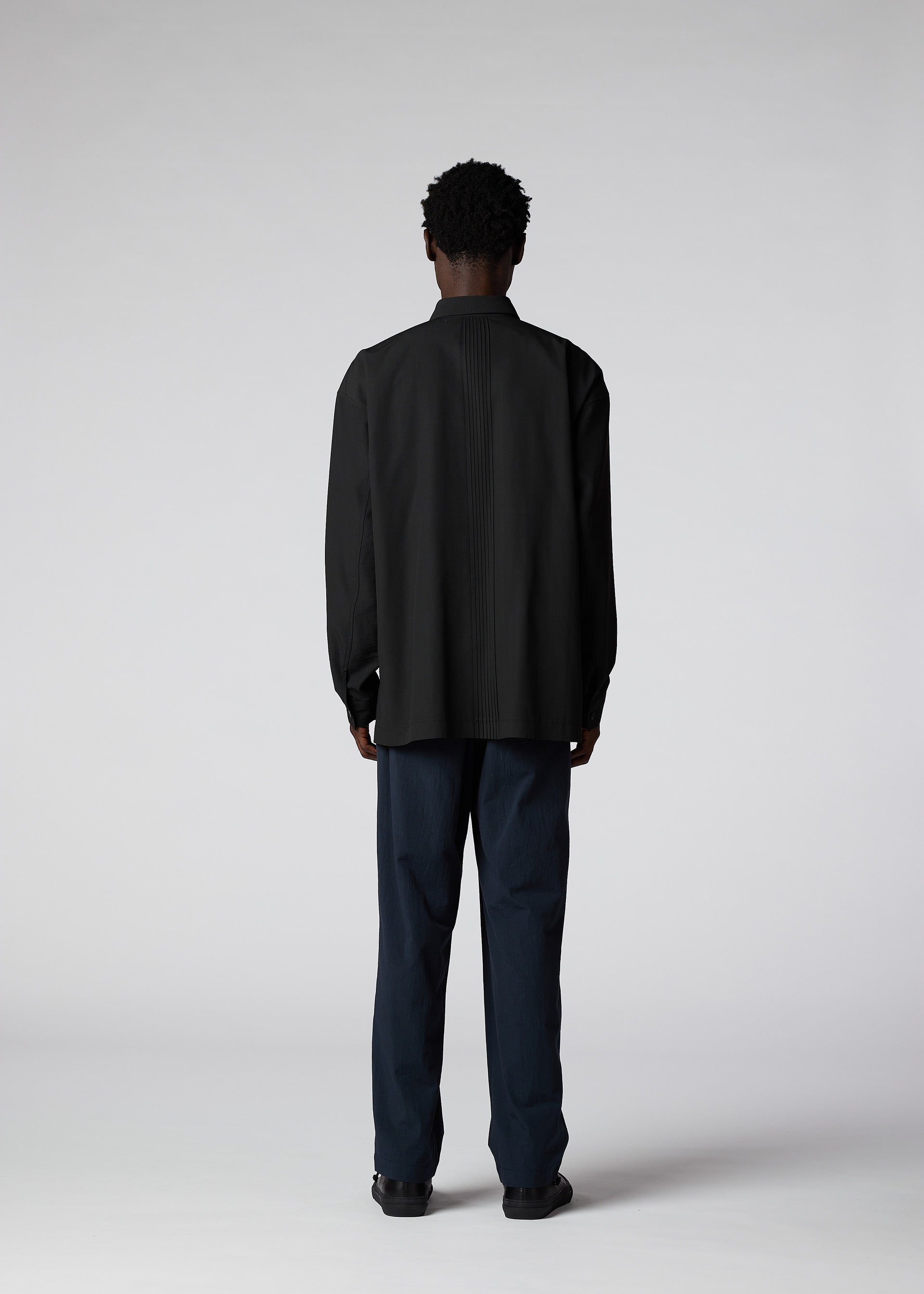 A model wears the IM MEN PLEATS SHIRT shirt.