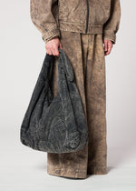 A model wears the IM MEN ELEMENTS BAG bag.