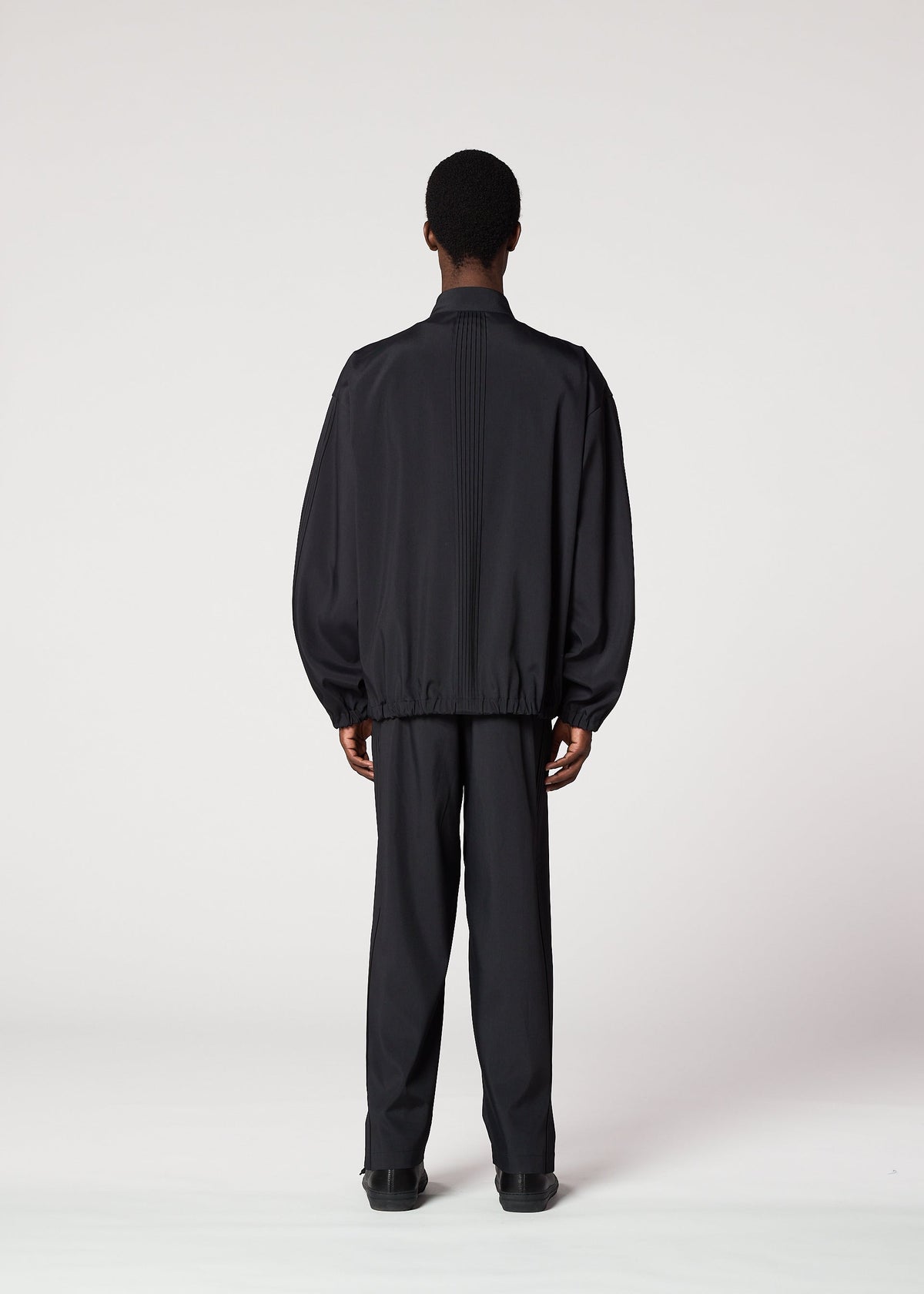 A model wears the IM MEN AIR PLEATS jacket.