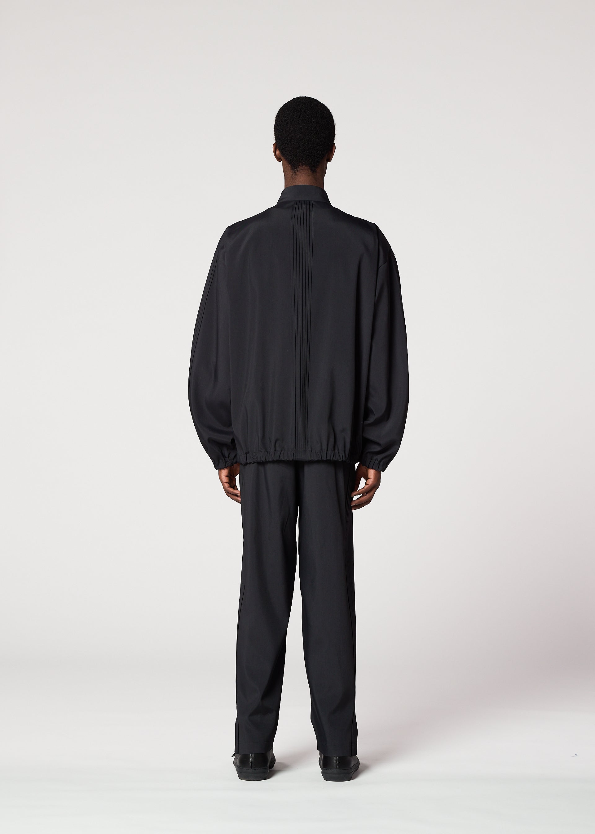 A model wears the IM MEN AIR PLEATS jacket.