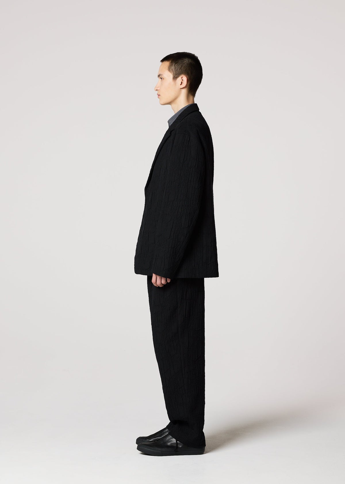A model wears the IM MEN SHRINK JACQUARD clothing.