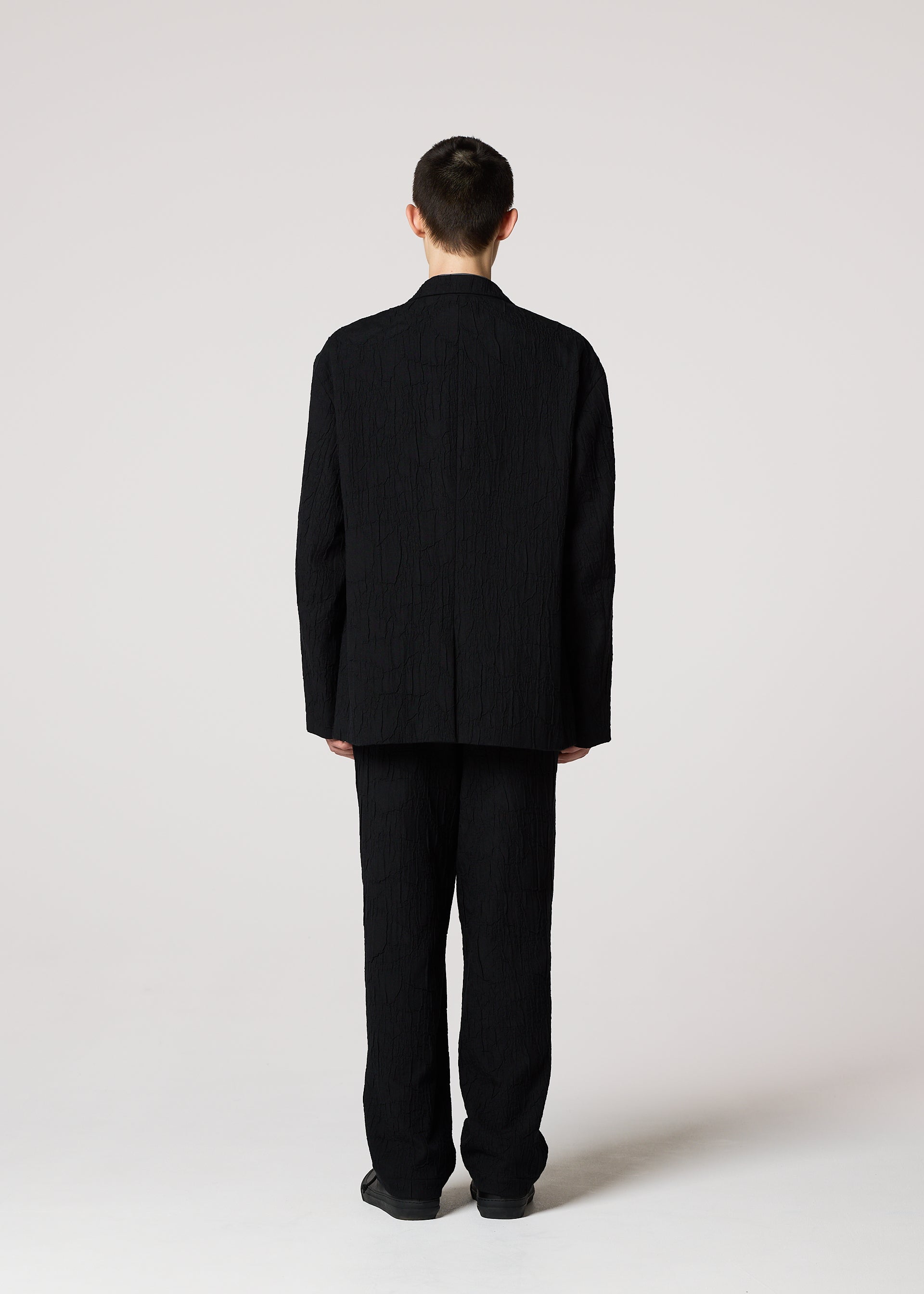 A model wears the IM MEN SHRINK JACQUARD clothing.